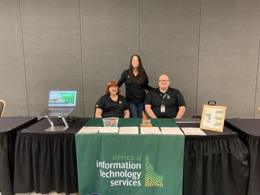 Four people at ITS job fair booth.