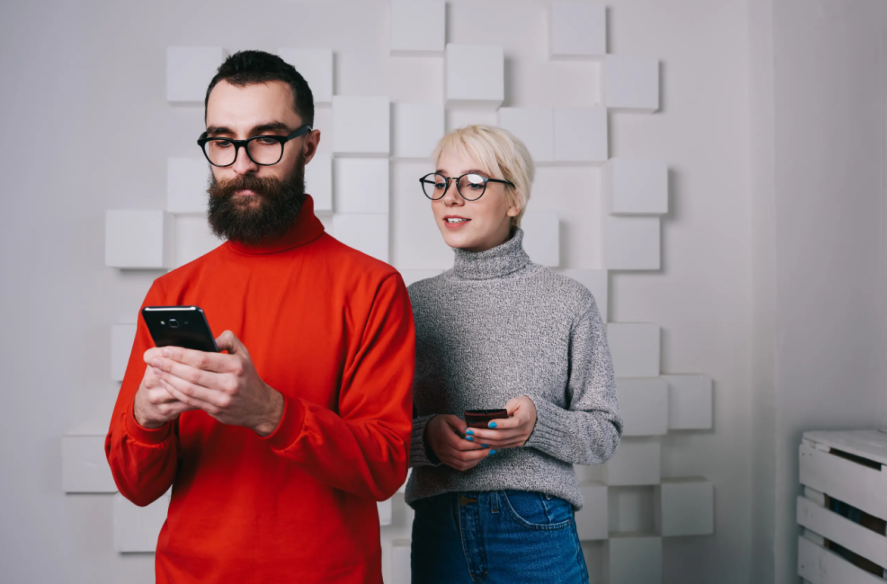 Generic Adobe stock: woman shoulder surfing as man uses his phone