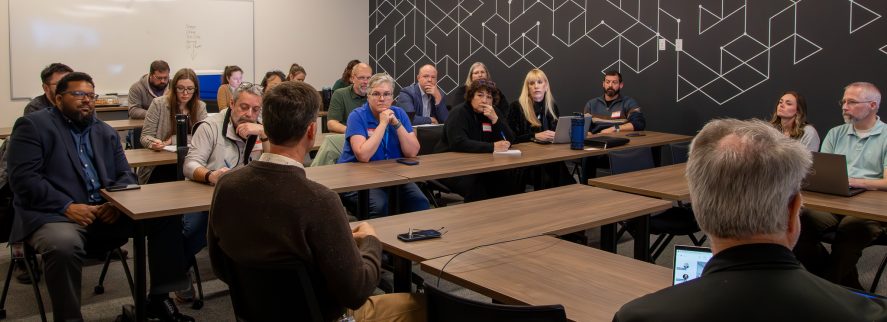 Multiple attendees at meeting showcased around desks